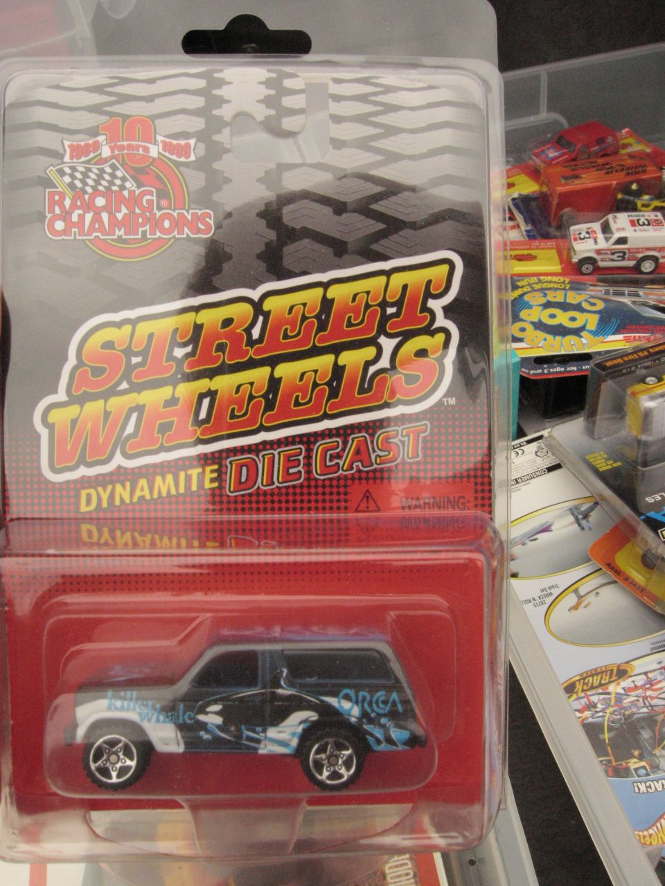 Diecast toy SUV with orca graphics in packaging