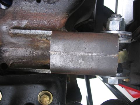 1989 Ford Bronco - Detail of a custom metal bracket welded onto a vehicle's suspension components.