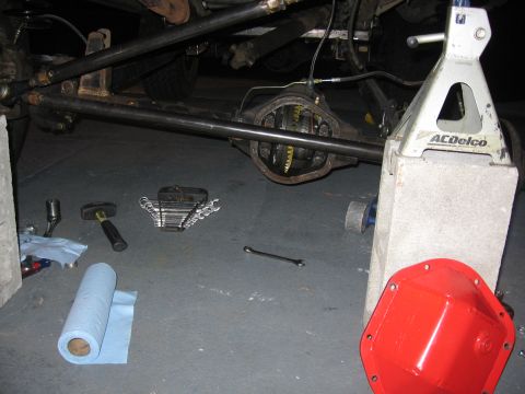 1989 Ford Bronco - The rear axle differential is exposed, with tools and a red differential cover nearby.