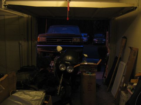 1989 Ford Bronco - A 1989 Ford Bronco is parked in a garage, partially obscured by a motorcycle.