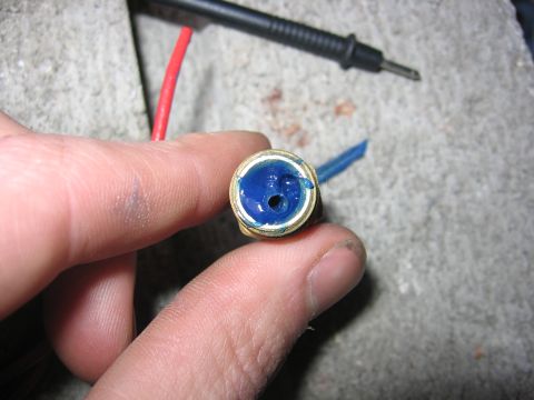 1989 Ford Bronco - Close-up of a hand holding a part filled with blue grease, with electrical components nearby.