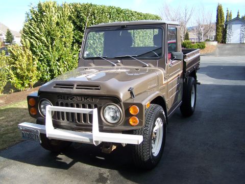 1988 Suzuki Samurai - This 1988 Suzuki Samurai pickup truck is shown from a 3/4 front view, displaying its brown paint and white accents.
