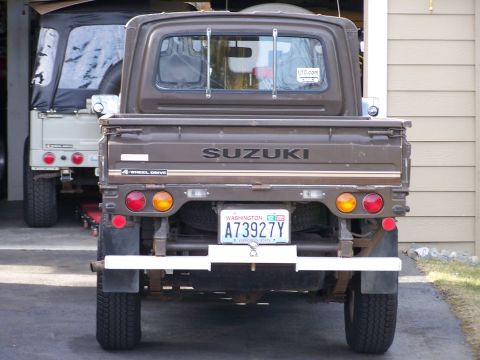 1988 Suzuki Samurai - Rear view of a 1988 Suzuki Samurai pickup truck, with another Suzuki vehicle behind it.