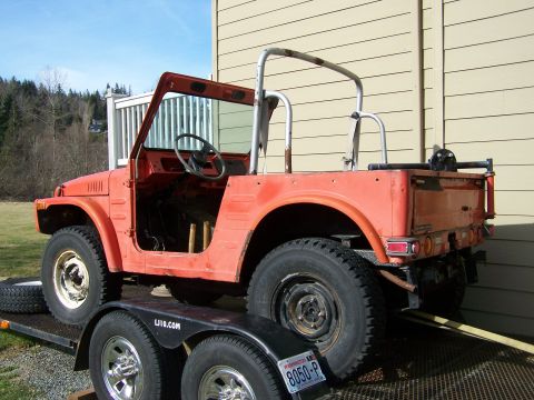 1988 Suzuki Samurai - This 1988 Suzuki Samurai is on a trailer, ready for transport. The vehicle is missing its doors and roof, and has a roll cage installed.
