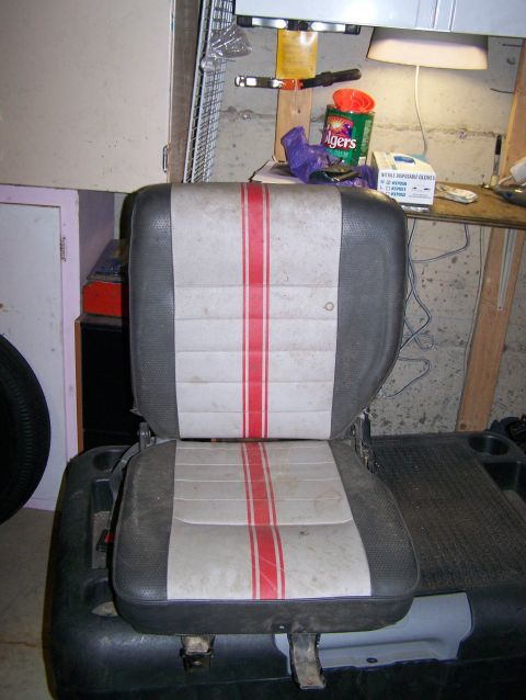 1988 Suzuki Samurai - A car seat with red stripes on light gray upholstery is shown, with various items in the background.