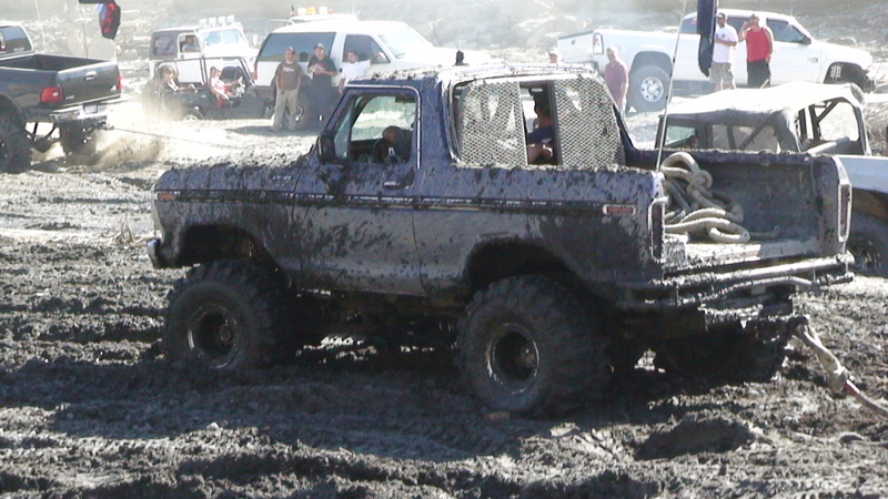 Mud-covered Ford Bronco at an off-road mud bog event