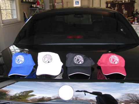 2003 Mercury Marauder - Four Mercury Marauder logo baseball caps are displayed on the trunk of a black car.