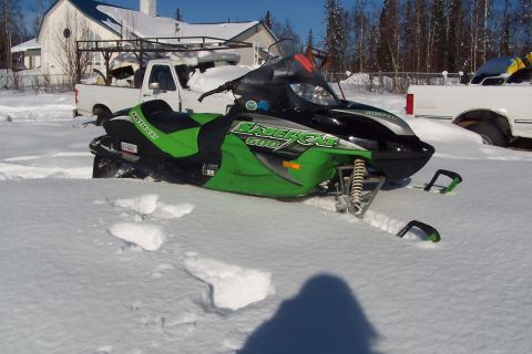 2004 Arctic Cat F-7 Firecat - Snowmobile parked in deep snow outside a building with a white pickup truck.