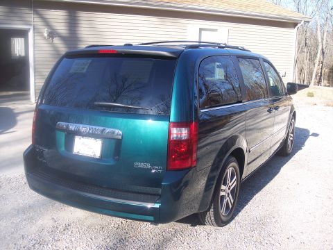 2007 Dodge Durango - Green Dodge Grand Caravan SXT parked in front of a house.
