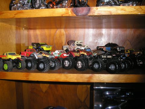 1995 Ford Bronco - A collection of toy monster trucks displayed on a shelf.