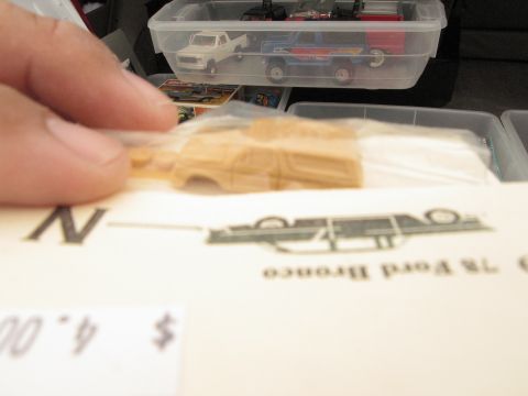 1986 Ford Bronco - Diecast model car parts and toy trucks are visible in plastic storage bins.