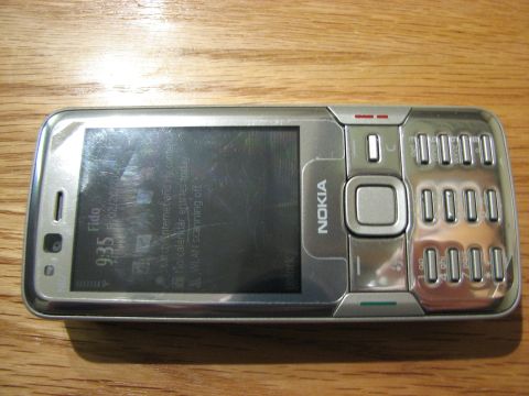2003 Ford Crown Victoria - A silver Nokia phone is displayed on a wooden table, showing the time and network information on its screen.