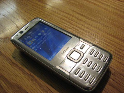 2003 Ford Crown Victoria - A silver Nokia mobile phone rests on a wooden table. The screen displays the time as 9:35 AM on February 20, 2009.