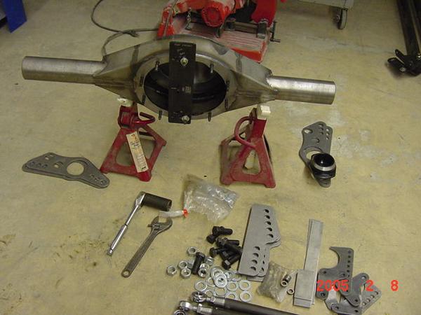 Rear axle assembly on jack stands with various hardware and brackets