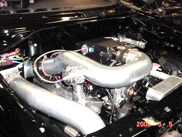 Engine bay with large intercooler piping and turbocharger components. Date stamp reads 2005 5 5