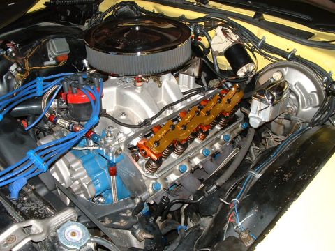 1978 Ford Ranchero - Close-up view of a V8 engine bay, a chrome air cleaner, orange valve covers, and blue spark plug wires.