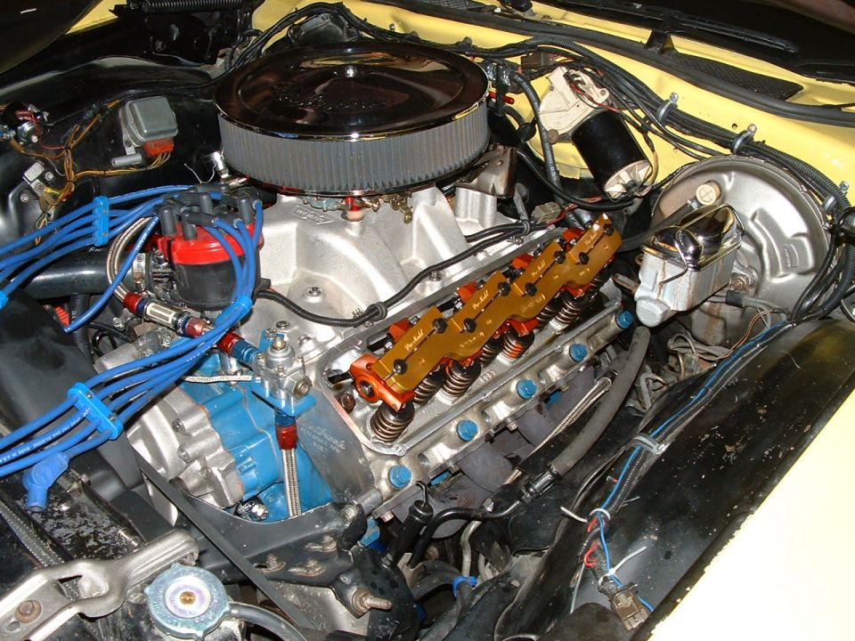 Engine bay with V8 engine, chrome air cleaner, and orange valve covers