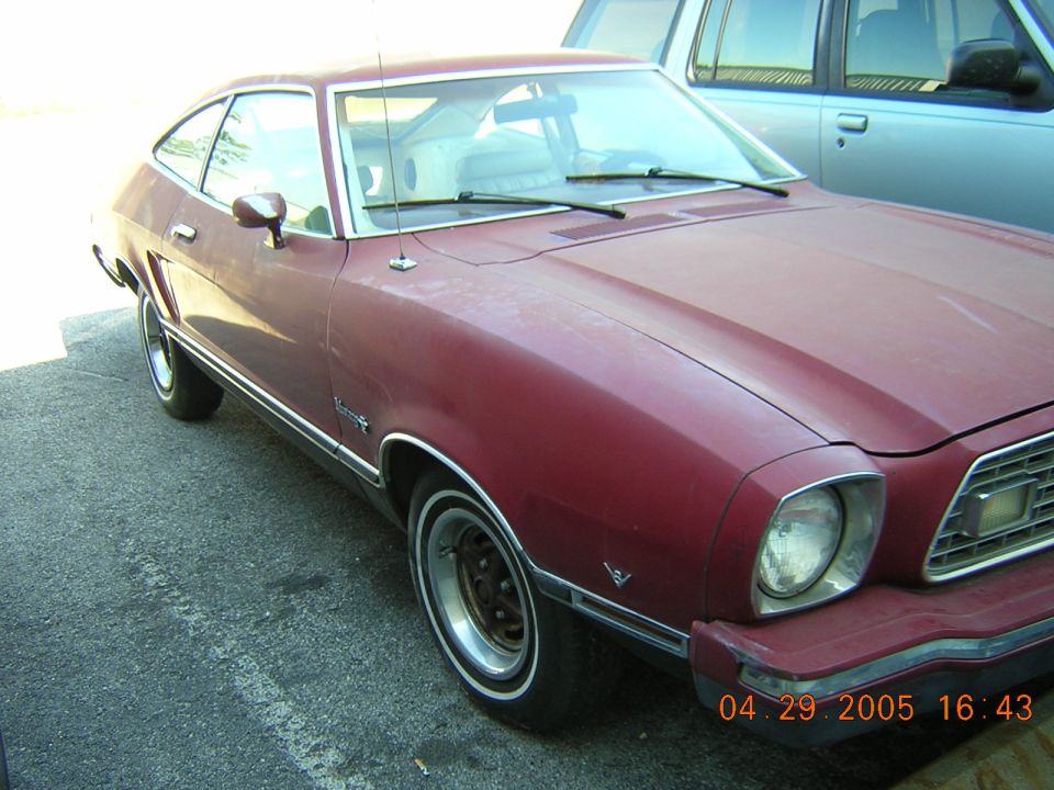 Maroon 1975 Ford Mustang II, front three-quarter view, parked on asphalt.