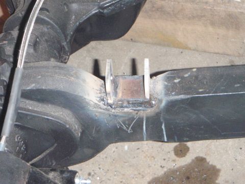 1996 Ford Bronco - A close-up view shows a custom metal bracket welded onto a dark-colored differential housing. The bracket has two vertical tabs and appears…