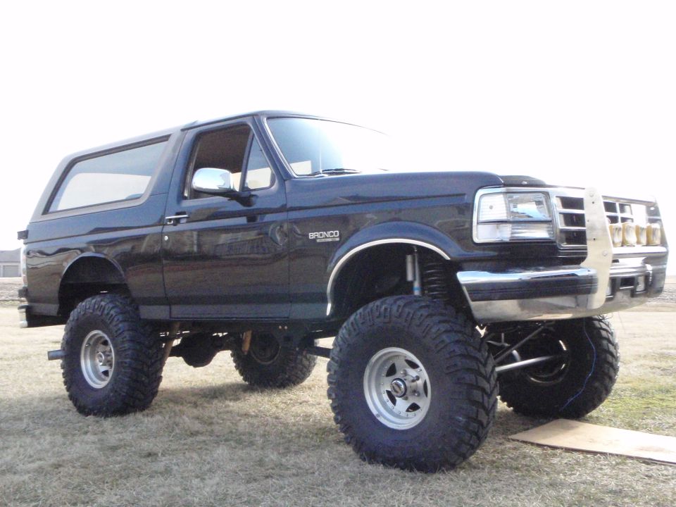 Lifted black 1996 Ford Bronco with off-road tires and grille guard.