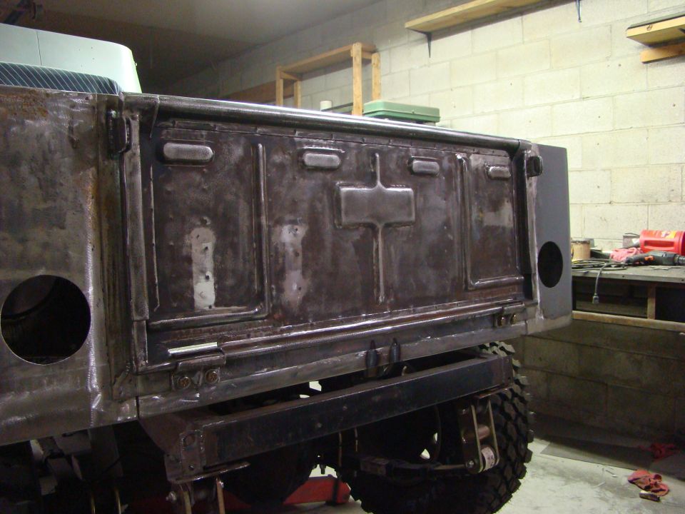 Raw metal Jeep CJ-2A pickup truck bed, passenger side view, showing panel details and welding.