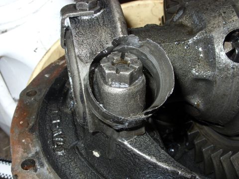 1988 Ford Bronco - A close-up view of a damaged differential housing with a broken ring gear and a nut that appears to have been sheared off. The metal compon…