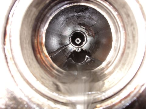 1988 Ford Bronco - A close-up, wide-angle view looking down into a dirty, wet pipe or exhaust system, possibly from a 1988 Ford Bronco.
