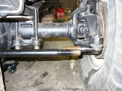 1988 Ford Bronco - A close-up view of the front axle and steering linkage of a vehicle, likely a 1988 Ford Bronco, showing the tie rod end connected to the st…