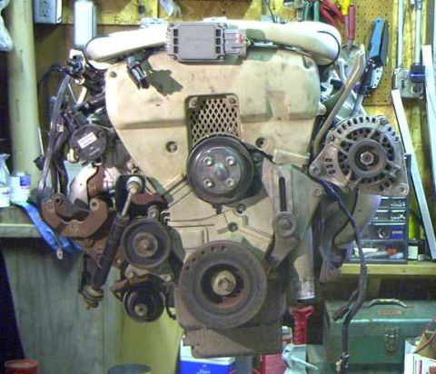 1993 Ford Taurus - Engine assembly components including alternator, pulleys, and wiring are visible in this workshop setting.