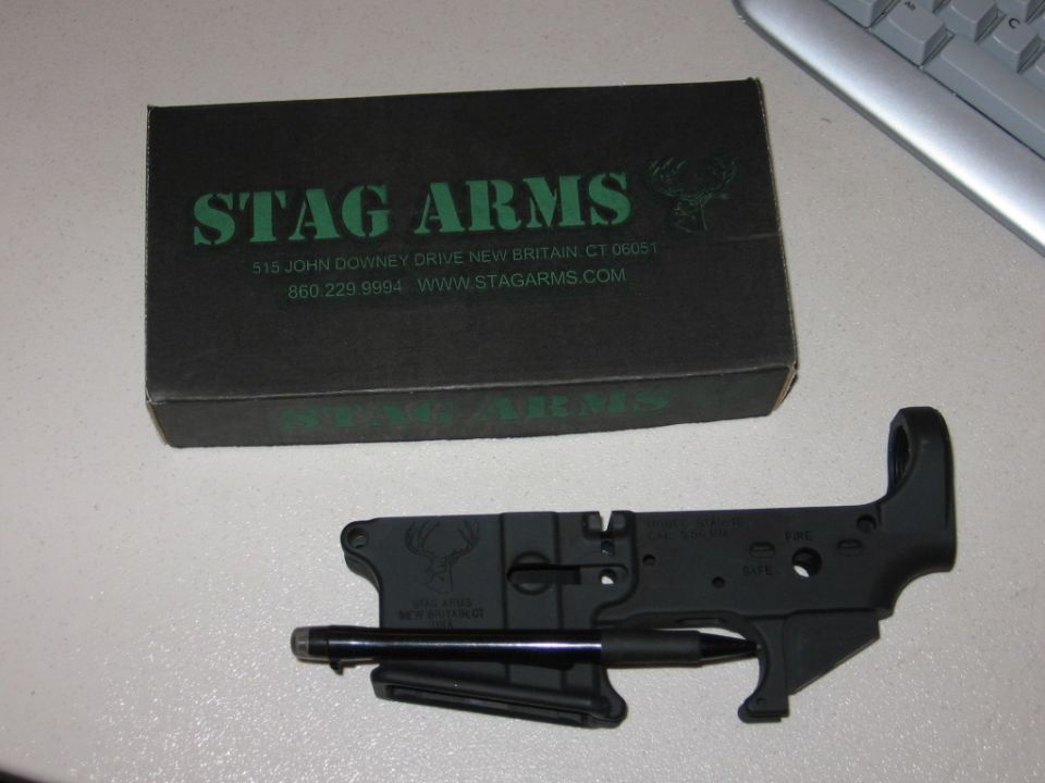 AR-15 lower receiver with Stag Arms logo and text, next to a Stag Arms product box