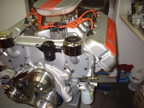 1970 Ford Mustang - A detailed view of a V8 engine, silver components and bright orange accents on the wiring and valve covers.