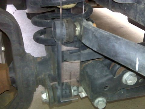 2008 Jeep Wrangler - A close-up view of a vehicle's suspension system, with a measuring tool attached to a component.