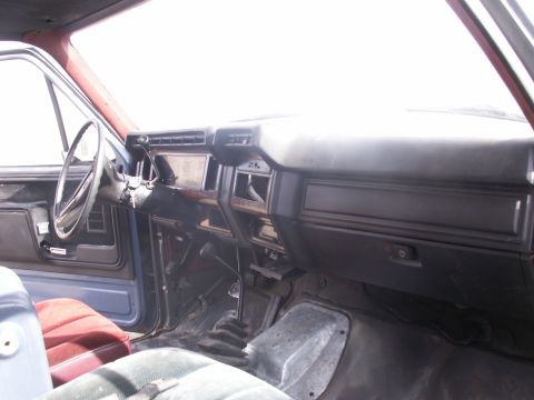 1986 Ford Bronco - Interior of a truck showing the dashboard, steering wheel, and manual shifter.