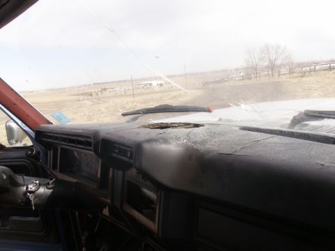 1986 Ford Bronco - Interior view of a vehicle's dashboard with a cracked surface and a view of the exterior landscape.