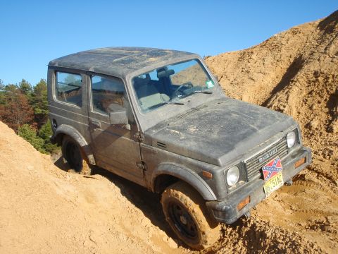1987 Suzuki Samurai - Suzuki Samurai navigating a steep dirt incline, showing off-road capability.
