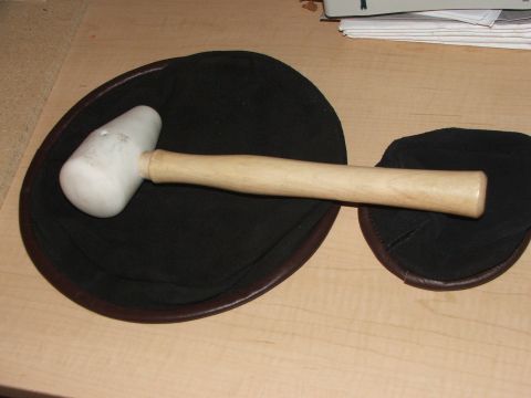 1965 Ford Mustang - A mallet with a wooden handle rests on two black pads, likely for automotive use, upholstery, or bodywork.