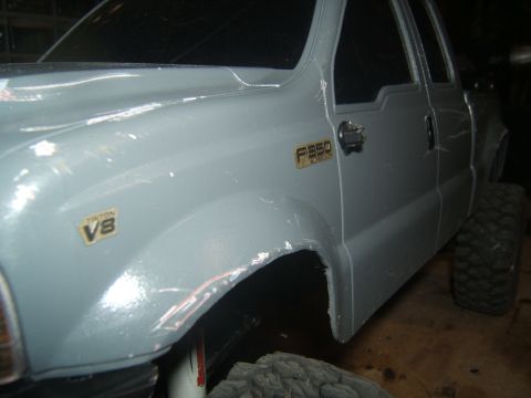 1988 Ford Bronco - Close-up of a gray RC truck's fender, showing F350 and Triton V8 badging.