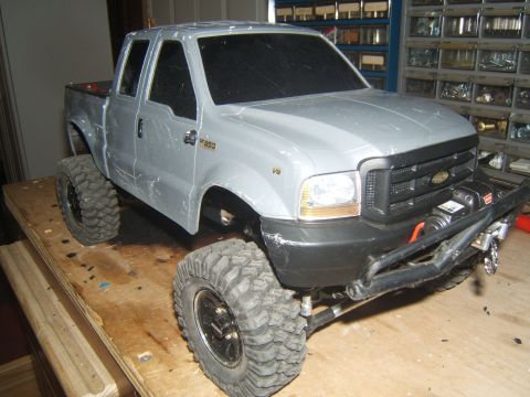 1988 Ford Bronco - RC truck model with F-350 badging and aftermarket winch, sitting on a workbench.