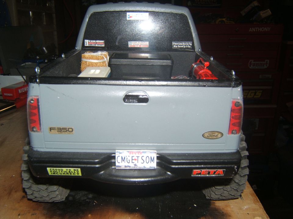 Gray Ford F-350 Super Duty pickup truck rear view with custom bumper stickers.