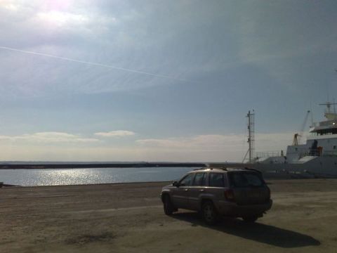 1991 Ford LTD Crown Victoria - Photograph of an SUV at a harbor beside a docked vessel, not a technical document.