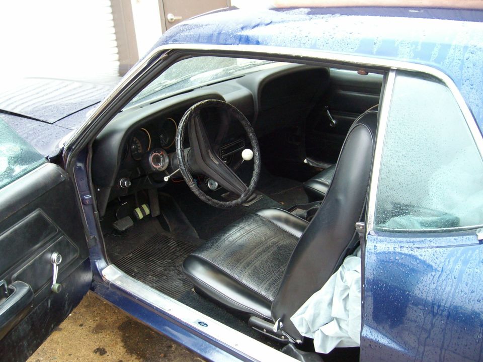 Interior of a blue 1970 Ford Ranchero showing seats, dashboard, and steering wheel.