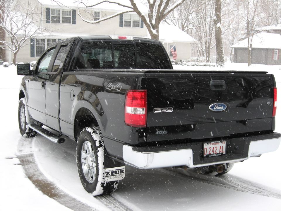 Black 2006 Ford F-150 pickup truck in the snow with Kansas license plate D 242 AL.