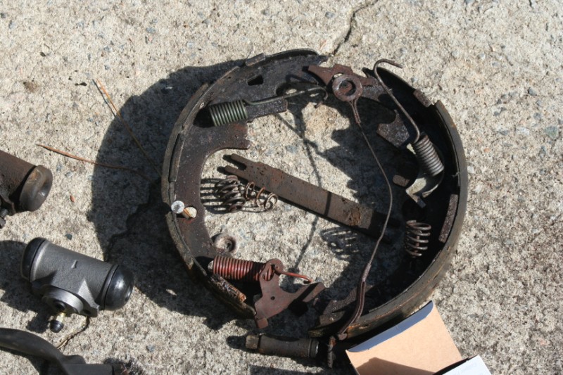 Used brake drums and hardware on concrete