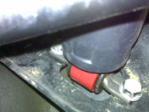 2008 Jeep Wrangler - A close-up view shows a red shock absorber with a silver bracket and a hex bolt, mounted to a black frame component that appears to be part…