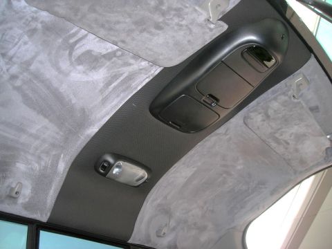 2007 Ford Mustang - Photograph of a vehicle roof interior with black overhead console and gray suede headliner, not a document.