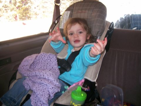 1993 Ford Bronco - A young child sits in a car seat inside a vehicle, with a purple knitted blanket on their lap. The child is wearing a blue hooded sweatshir…