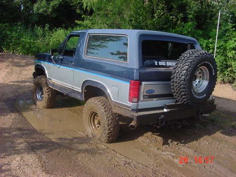 1986 Ford Bronco - This 1986 Ford Bronco is navigating a challenging muddy terrain, its off-road capabilities.