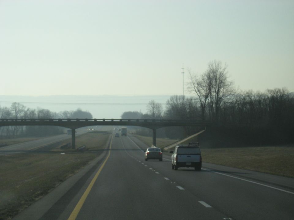 Highway passing under an overpass with vehicles ahead