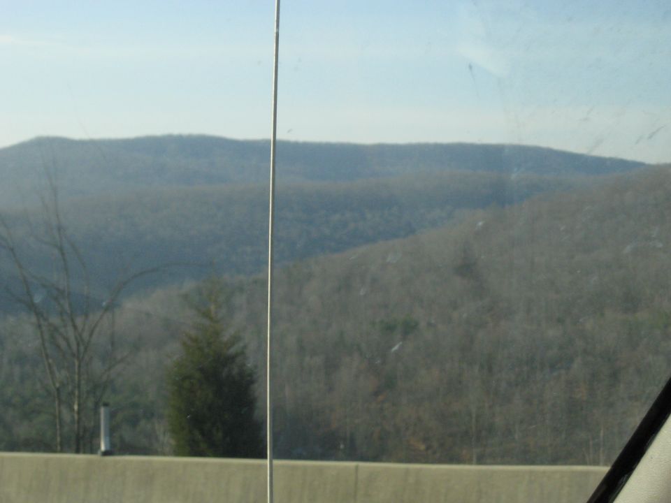 Forested mountain ridge viewed through a vehicle window