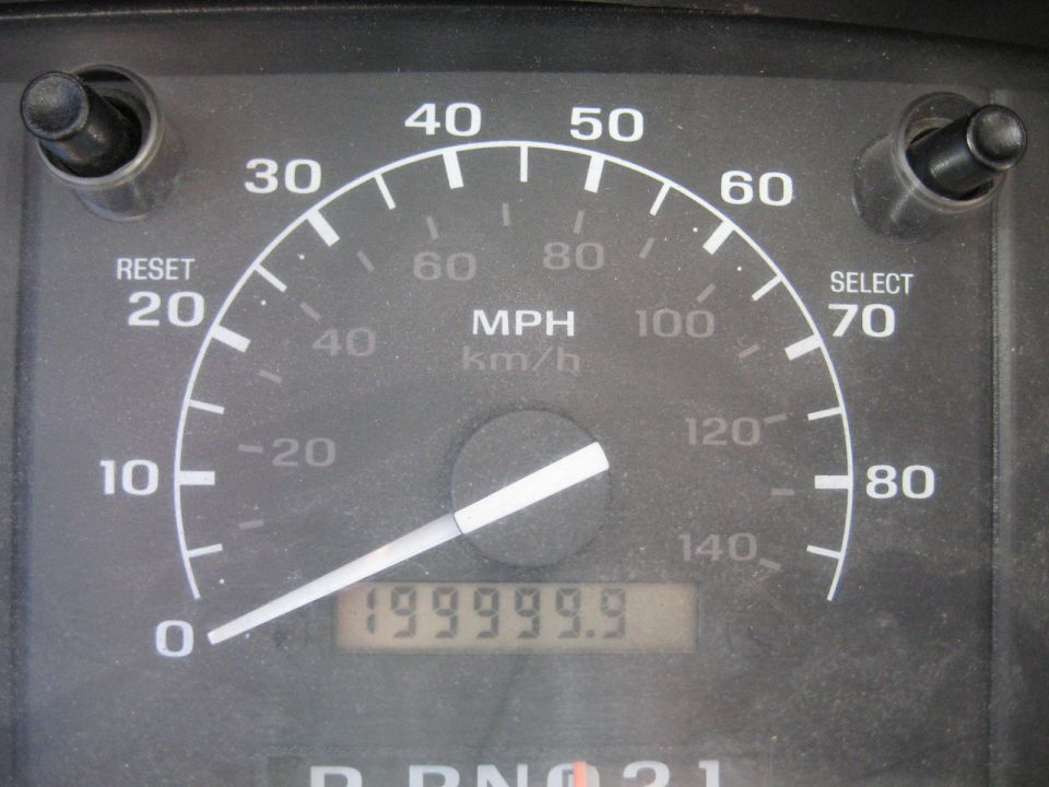 Close-up of a vehicle speedometer gauge reading 199999.9 miles